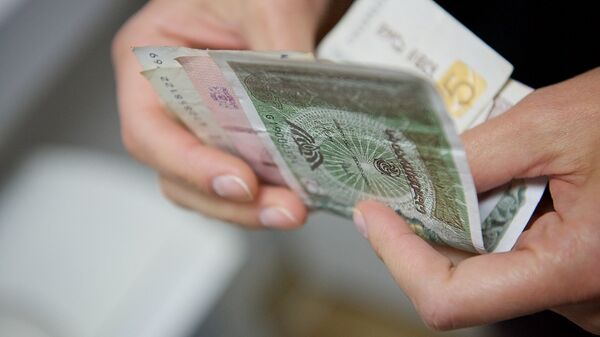 Человек держит в руках купюры грузинской валюты лари различного номинала - Sputnik Грузия